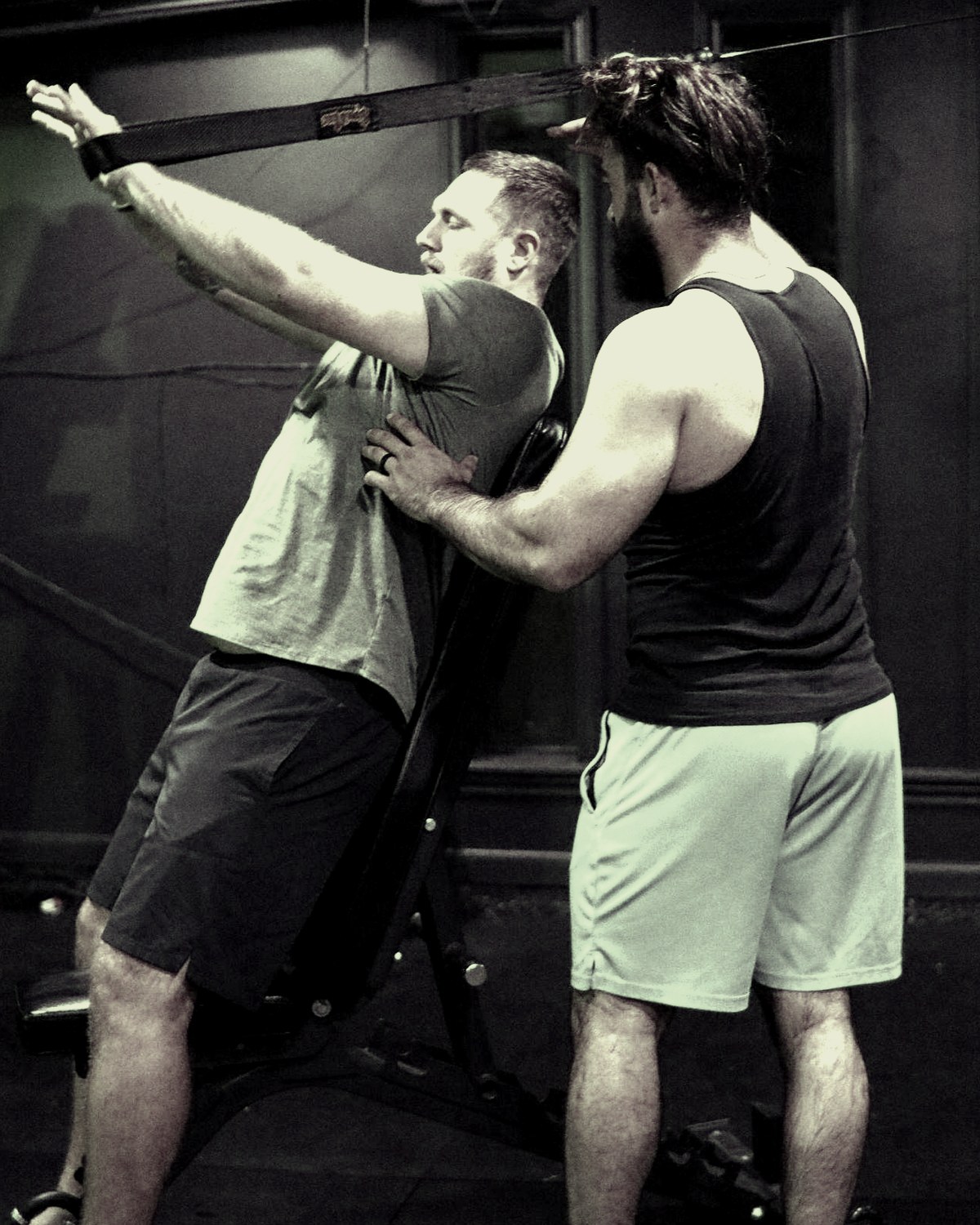 Andrew Mangum coaching a client through a lift in his gym